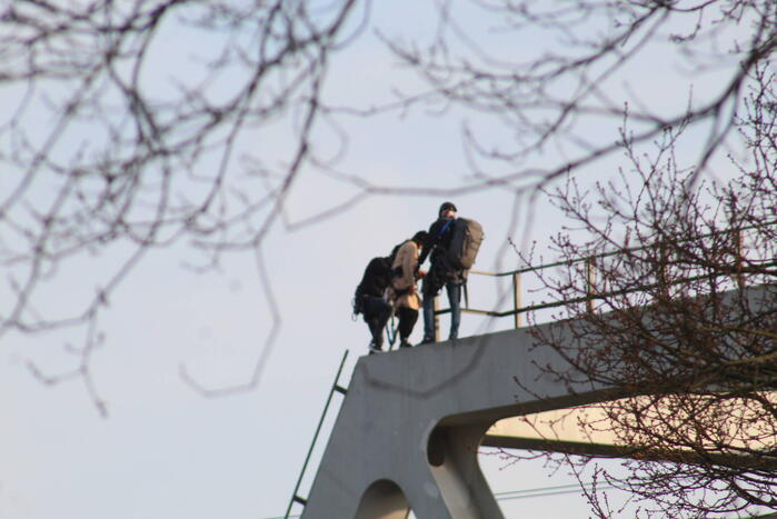 Persoon op bogen van brug, vele hulpdiensten aanwezig